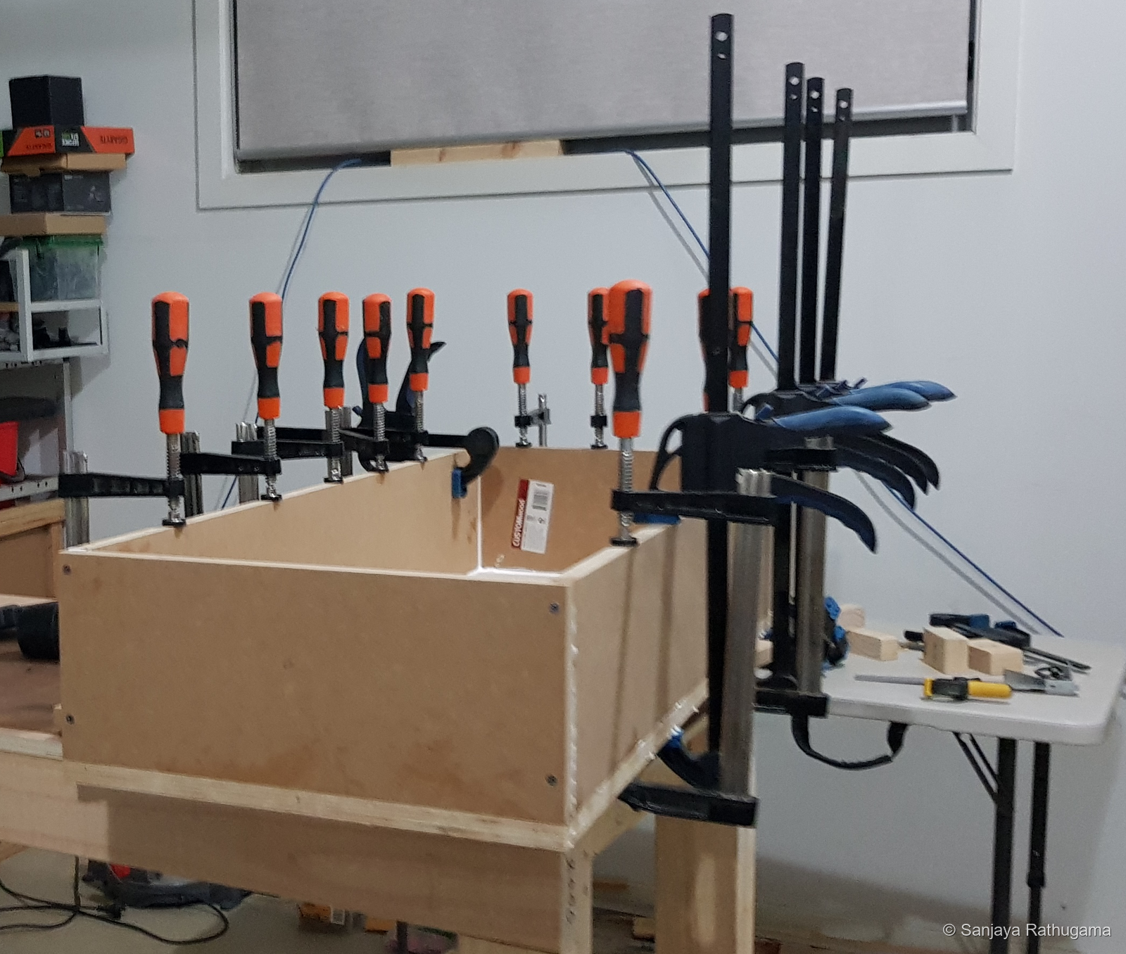 Shallow speaker cabinet clamped on the workbench during assembly