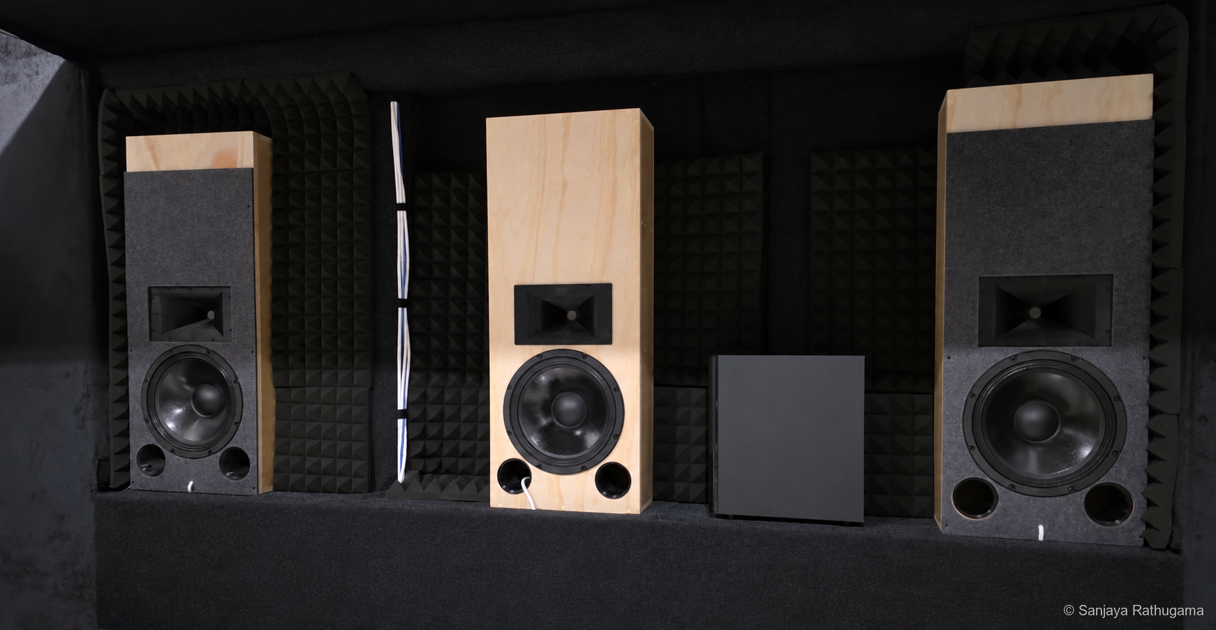 Three matching vertical horn-loaded LCR speakers in the developing home-theatre front wall