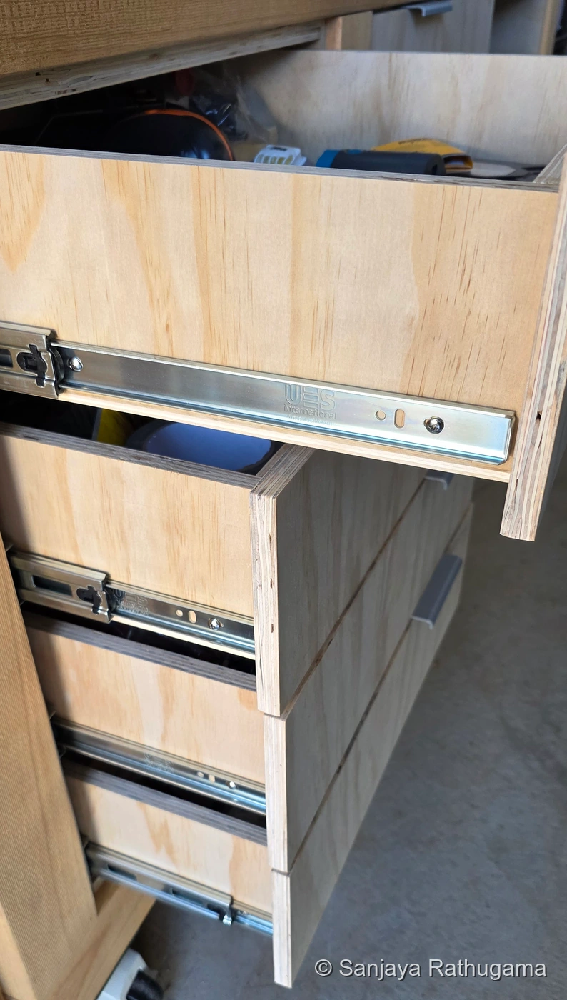 Completed plywood drawers pulled open, showing fitted telescopic runners, separate fronts and tools inside